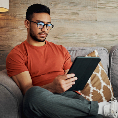 Man reading blog on tablet in living room